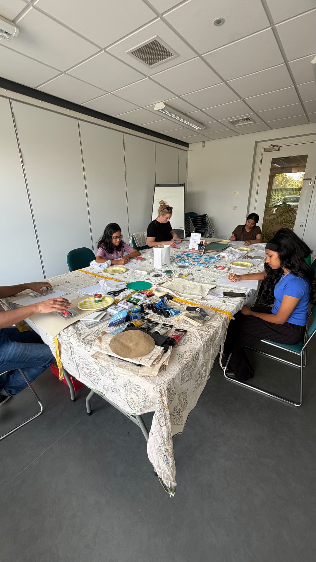 A group seated around a long table, printing together