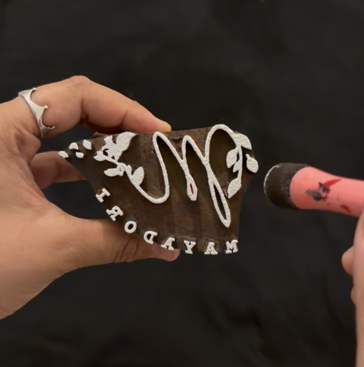A hand-carved lino stamp being printed onto paper