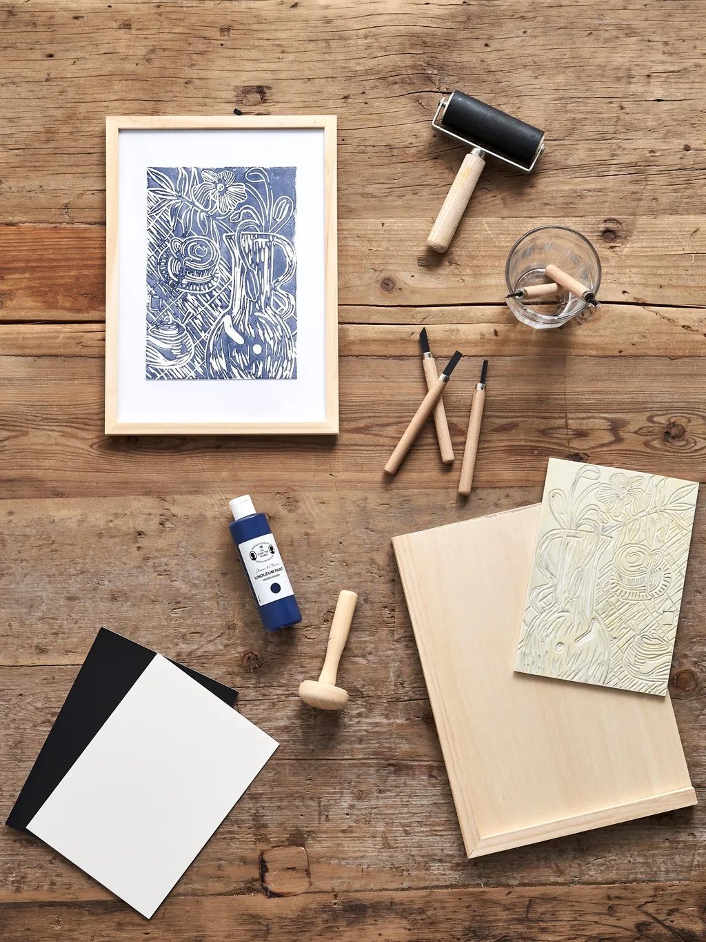 Carve-at-Home lino printing kit laid out on a wooden table