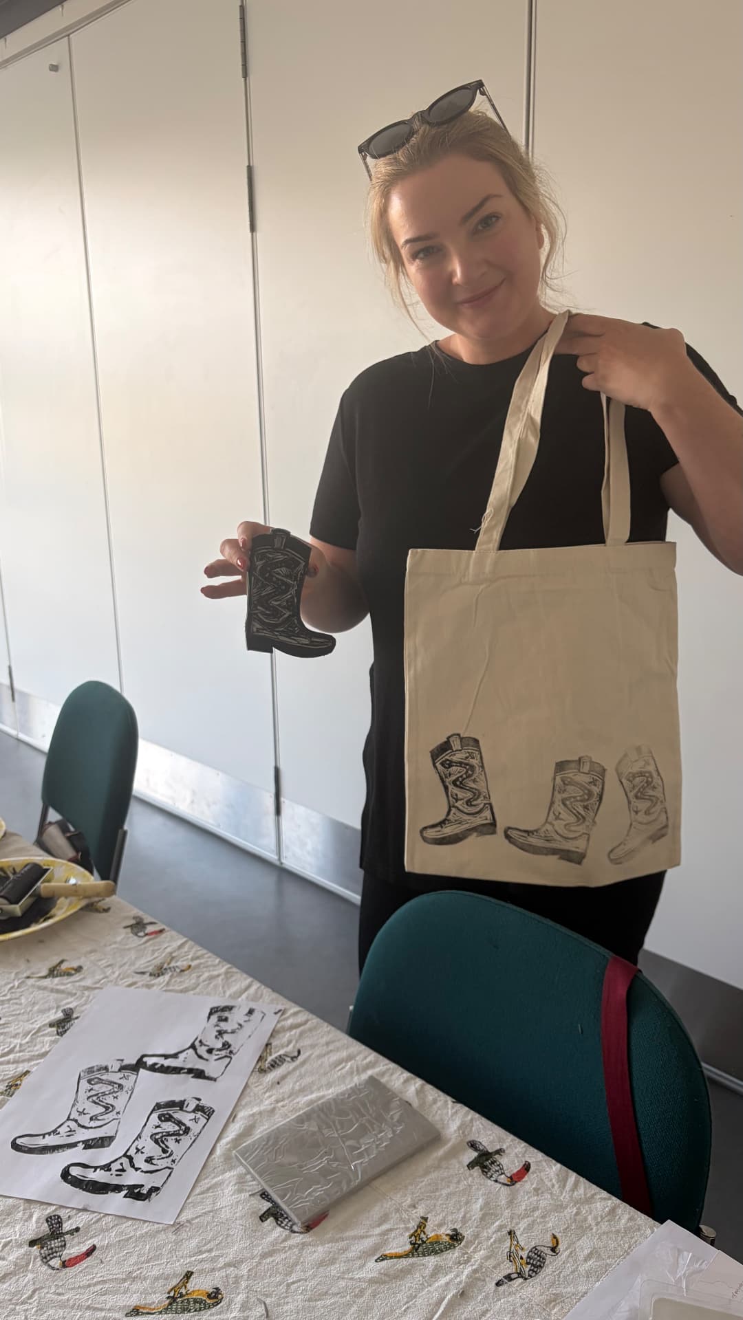 A participant holding up her hand-printed tote bag