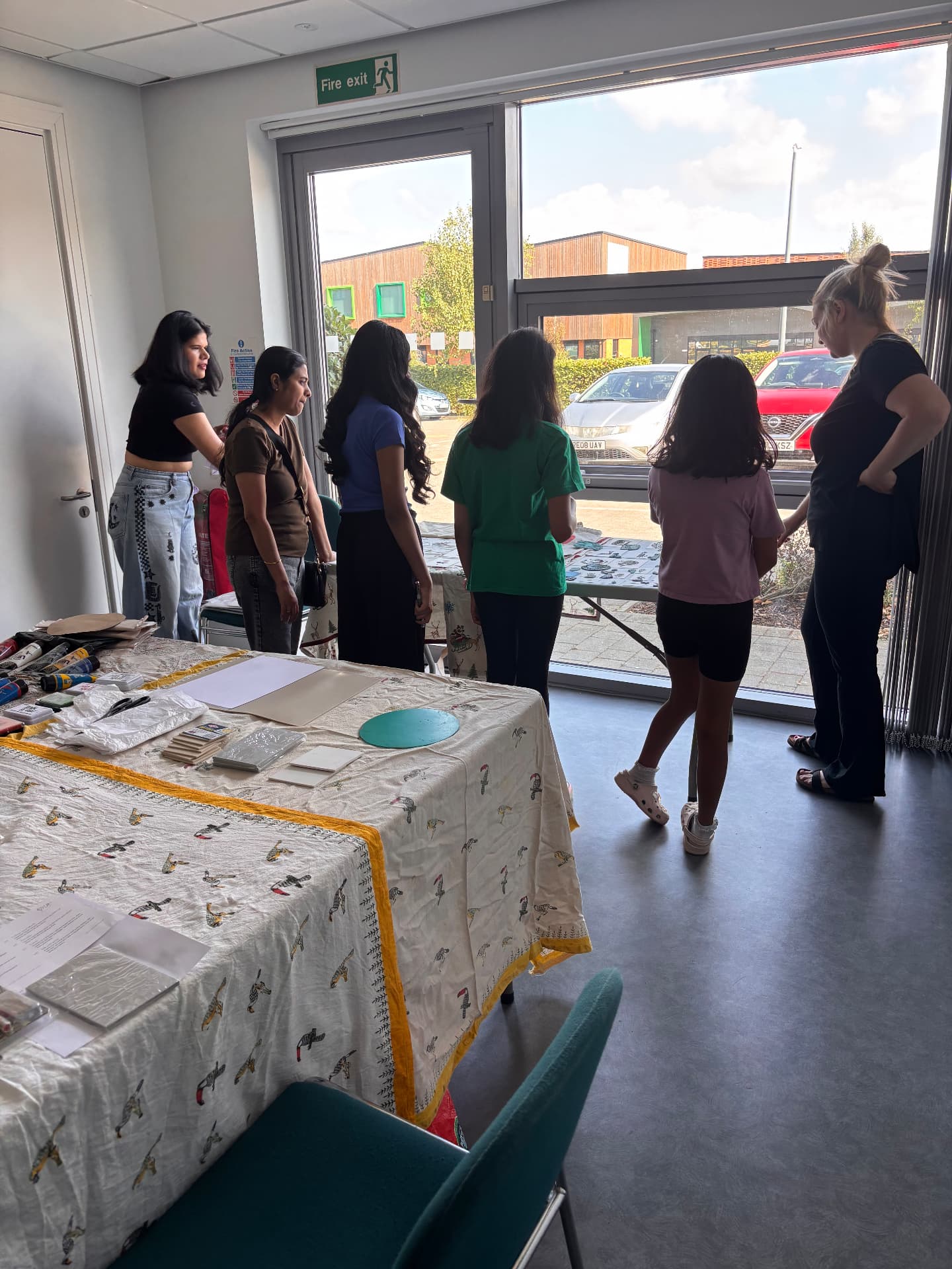 Adults and children chatting around the printing table at a workshop